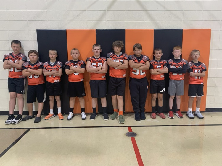 boys in football jerseys against wall in gym 