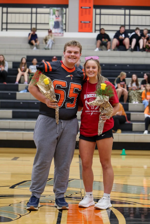 Homecoming Kind and Queen holding yellow roses