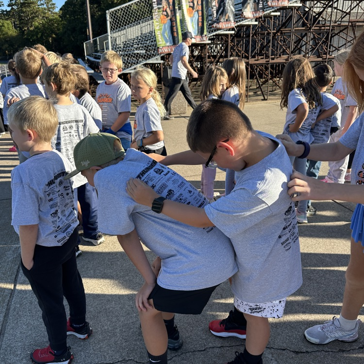 students looking at writing in backs of tshirts 