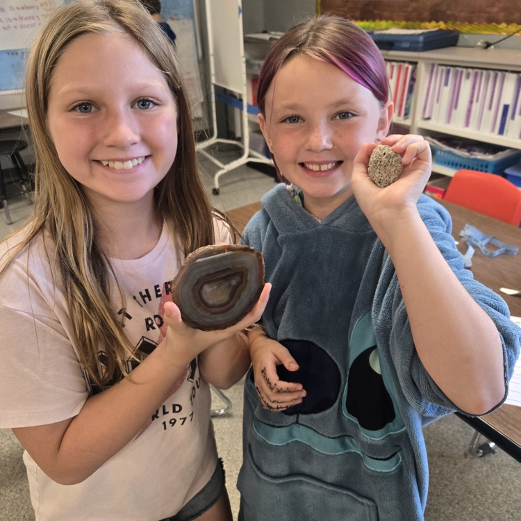 students holding rocks