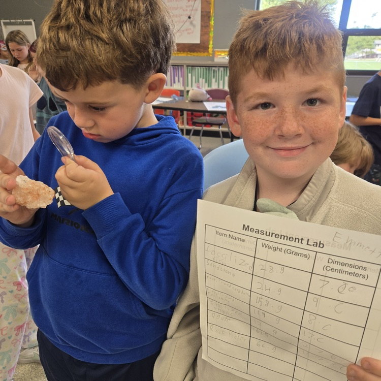 student using magnifying glass to examine rocks