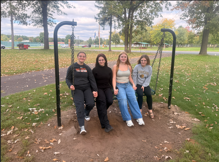 four girls on swing holding hands