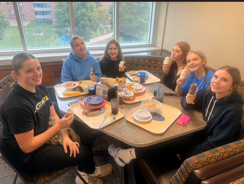 Six students eating ice cream cones in a booth