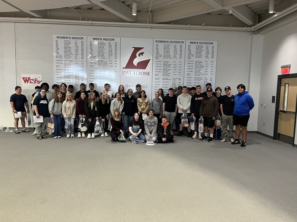 Students posing in front of UW-Lacrosse sign in Track and Field Building