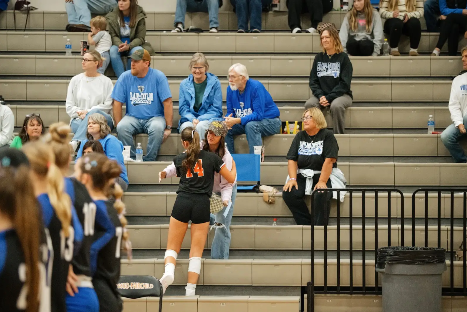 volleyball player hugging parent in bleachers