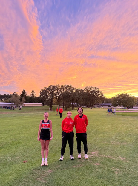 cross country runners in front of sunset sky