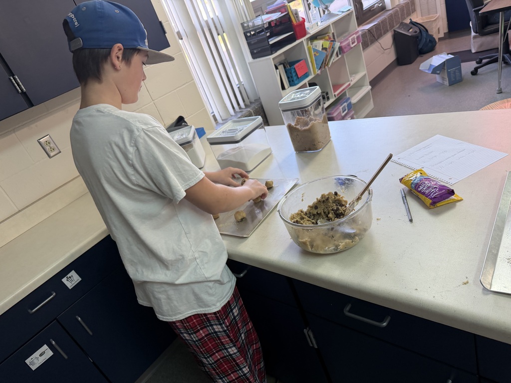 student forming cookies on cookie sheet