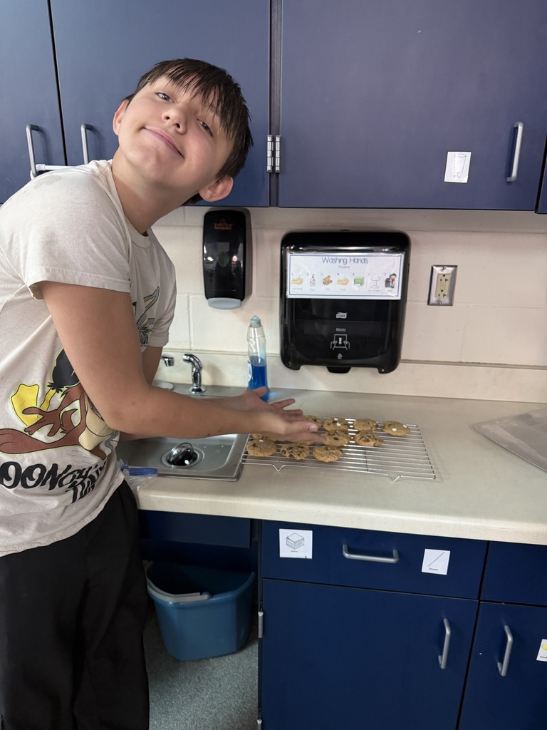 Student showing cookies on cooling rack