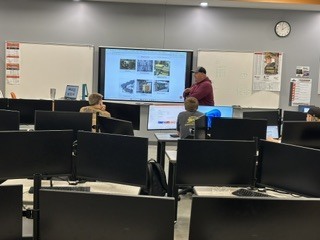 man presenting infront of students in classroom