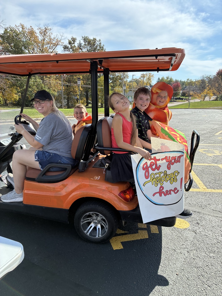Students riding on an orange golf cart