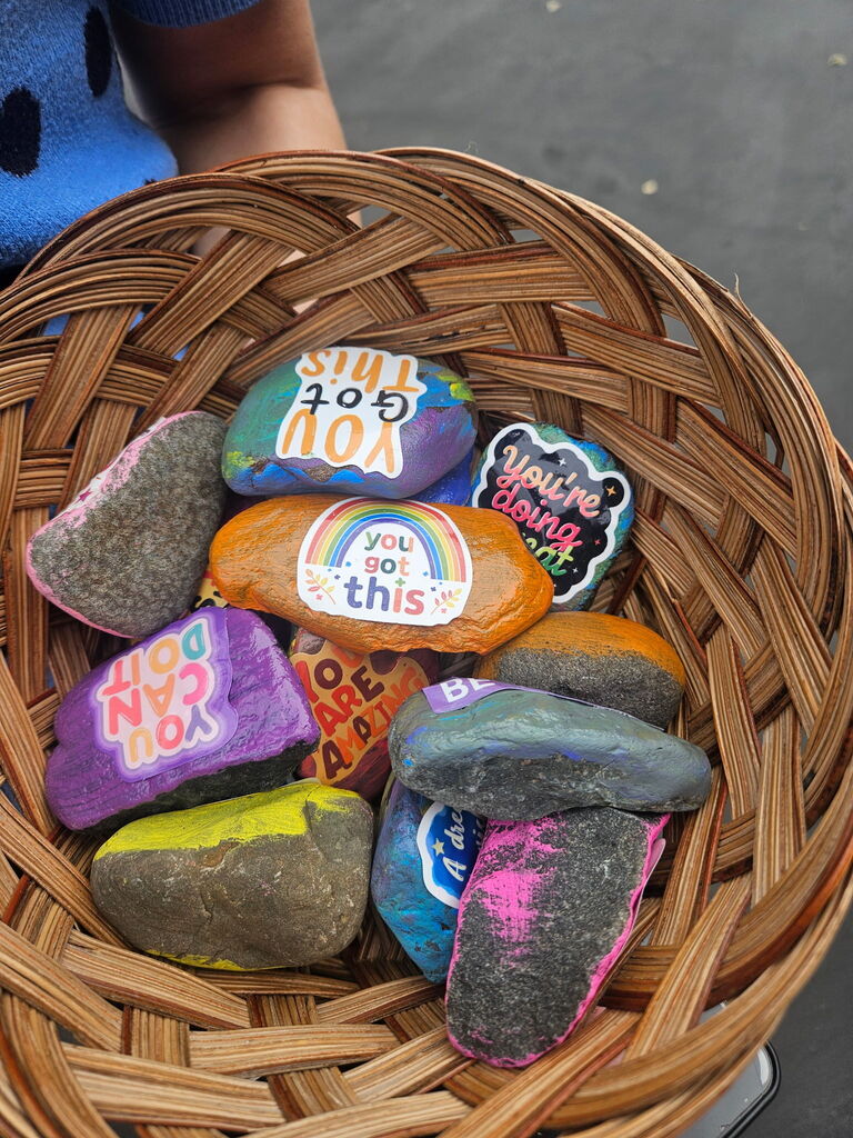 Image description for accessibility:   basket of painted rocks with positive messages