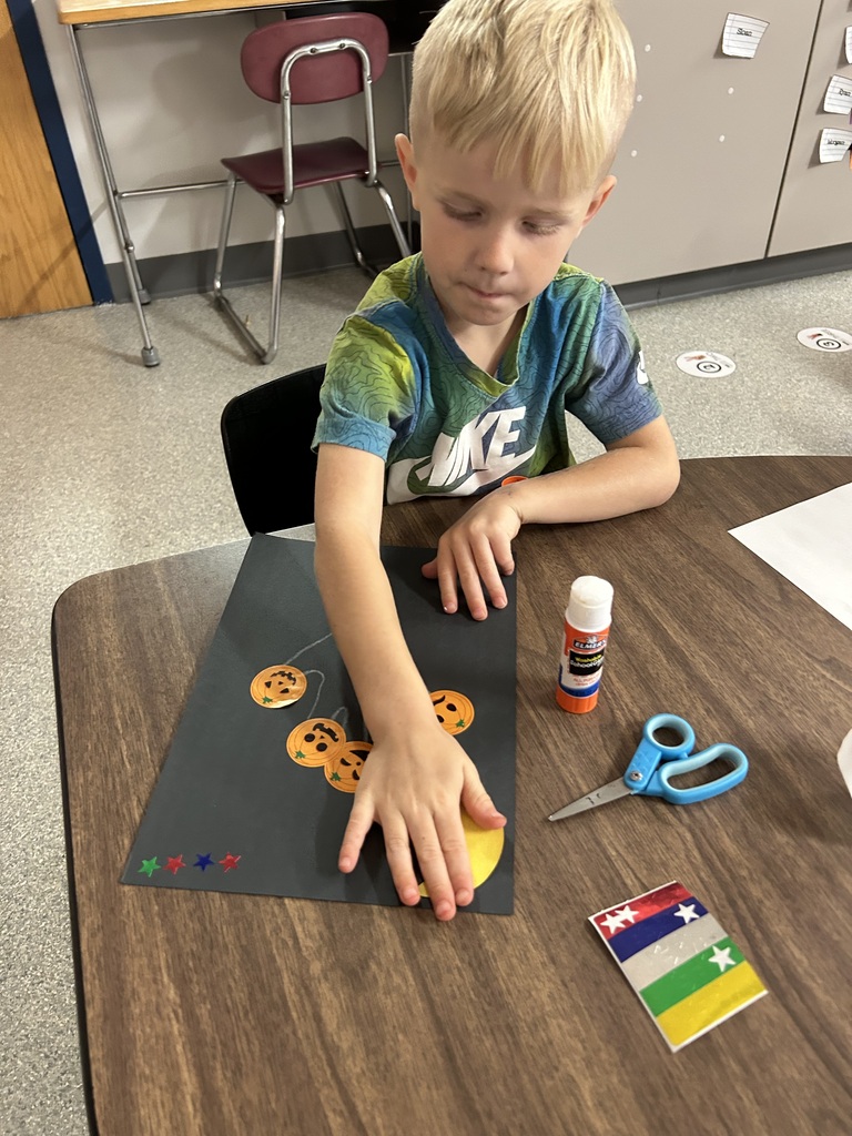 Image Description for accessibility: Student working on pumpkin artwork