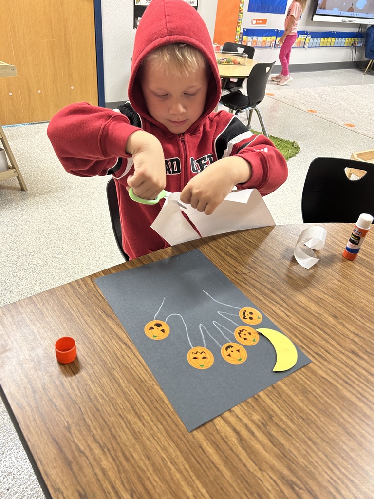 Image Description for accessibility: Student working on pumpkin artwork