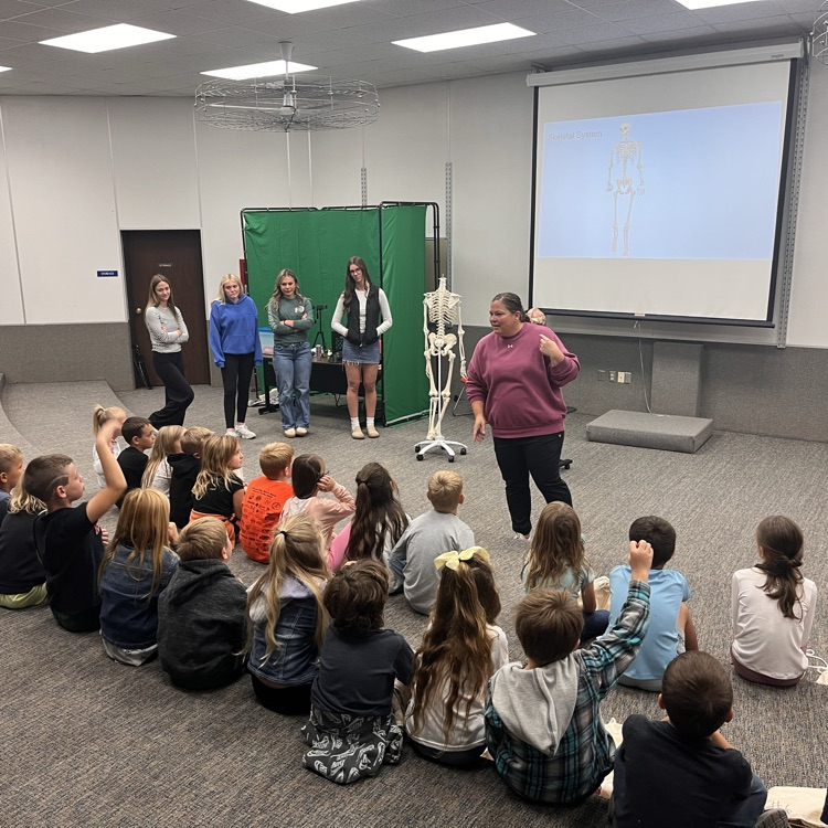 Image Description for Accessibility: teacher presenting in front of group