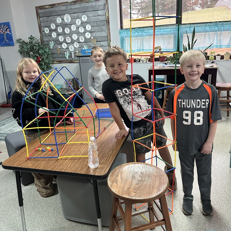 Image description for accessibility: students playing with plastic rods to build structures 