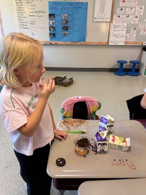 Image Description for accessibility:  Student eating a messy snack at her desk