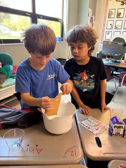 Image Description for accessibility:  Students making a snack in classroom