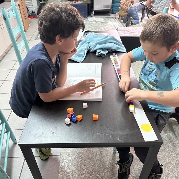Students measuring with cube