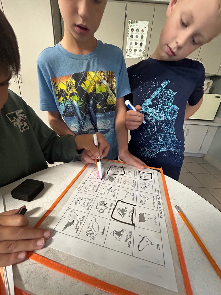Image description for accessibility:  three students looking at a table 