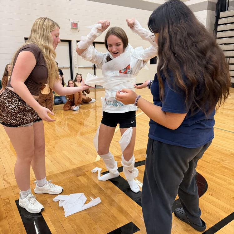 Image description for accessibility two students wrapping a third student in toilet paper