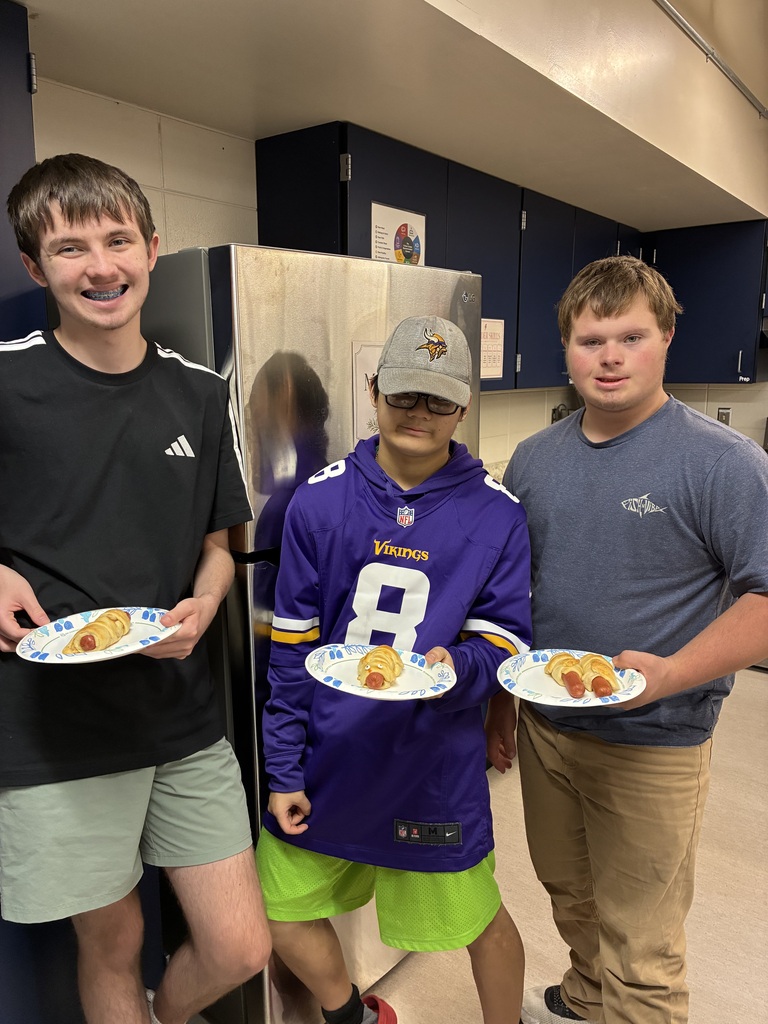 Image Description for accessibility: three students holding plates with hotdogs