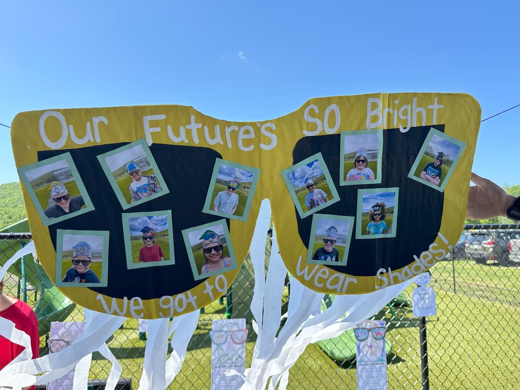 Sign in the shape of sunglasses with student pictures in it that says our future's so bright we got to wear shades