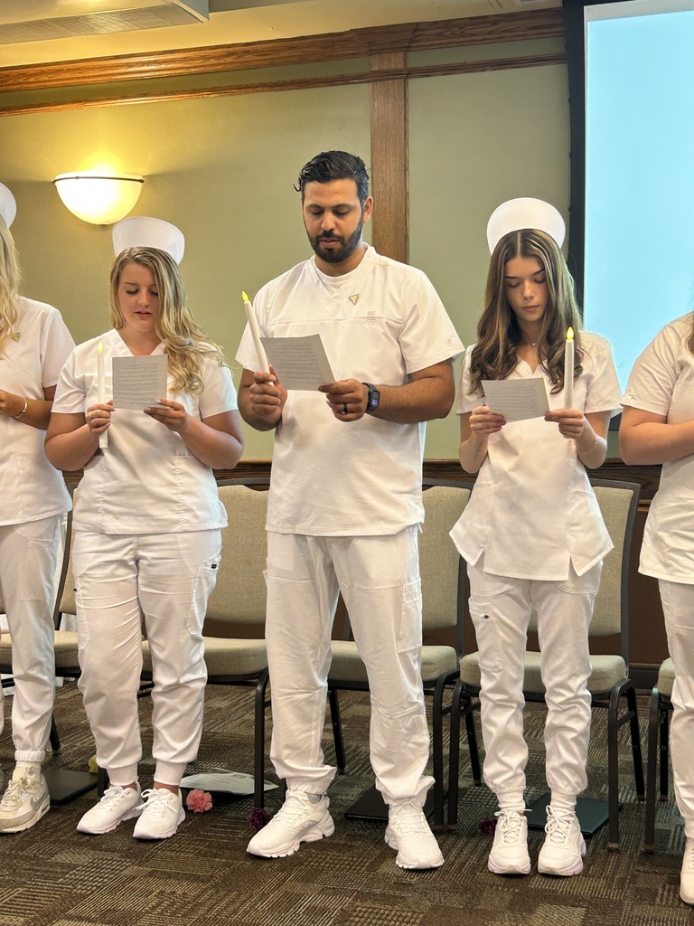 Students on stage with candles reading 