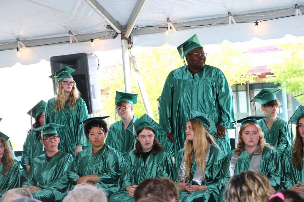 Two students standing being recognized while other students are sitting