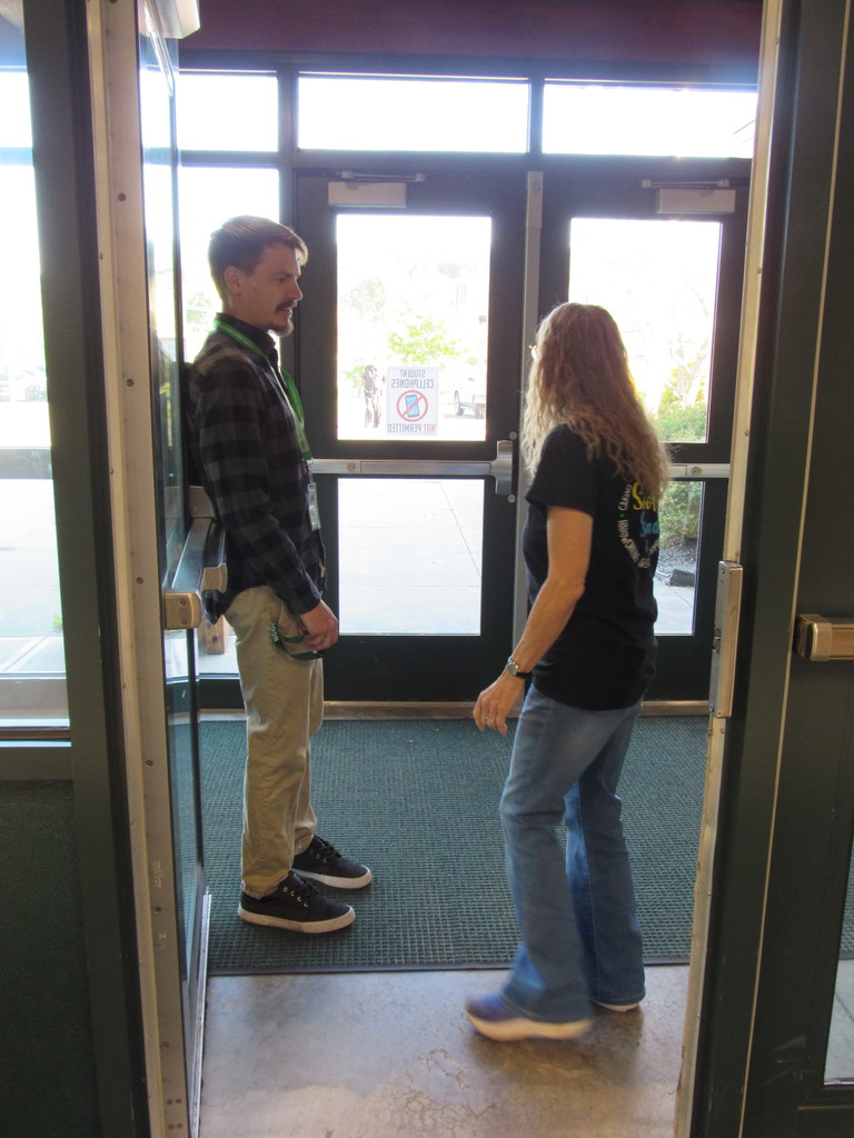 Two staff members at the door ready to greet students