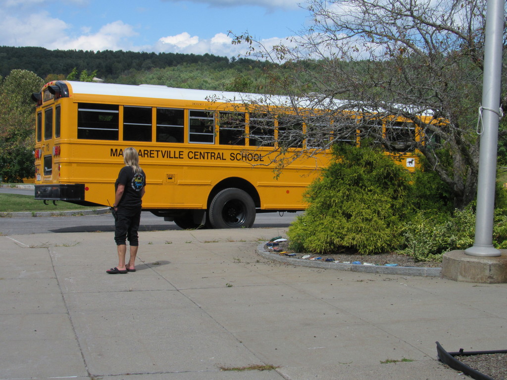 Margaretville CSD bus in the parking lot with staff member waiting for students