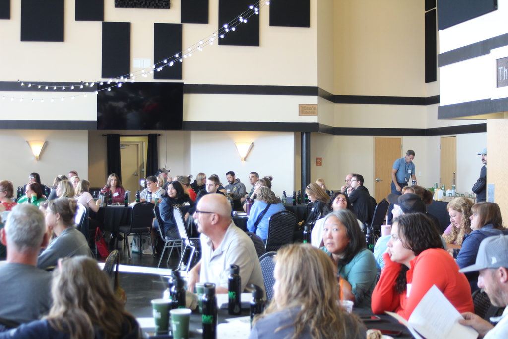 Large group of staff sitting at tables during a presentation