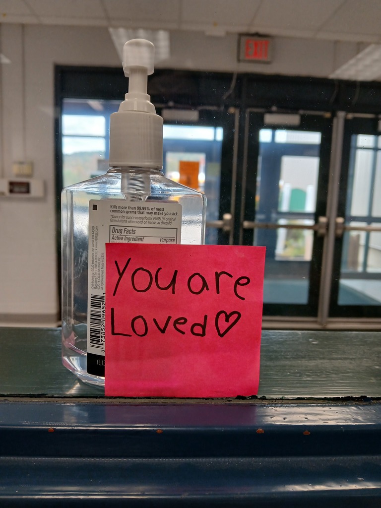 A note attached to a bottle that says, you are loved.