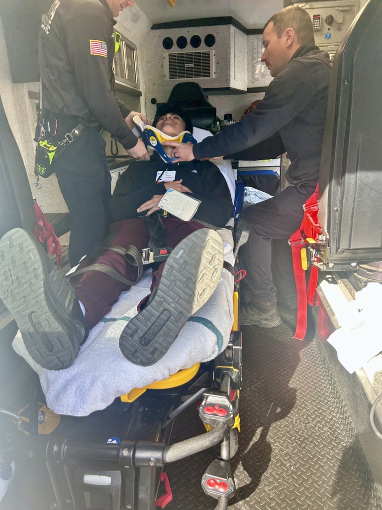 Two EMTs and a student acting as a victim inside an ambulance during the drill.