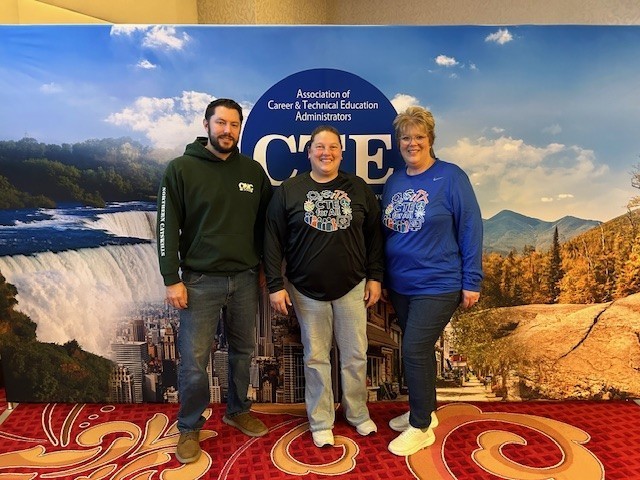 Jesse Bright, Tera Talbot, and April Erkson in front of the ACTEA sign