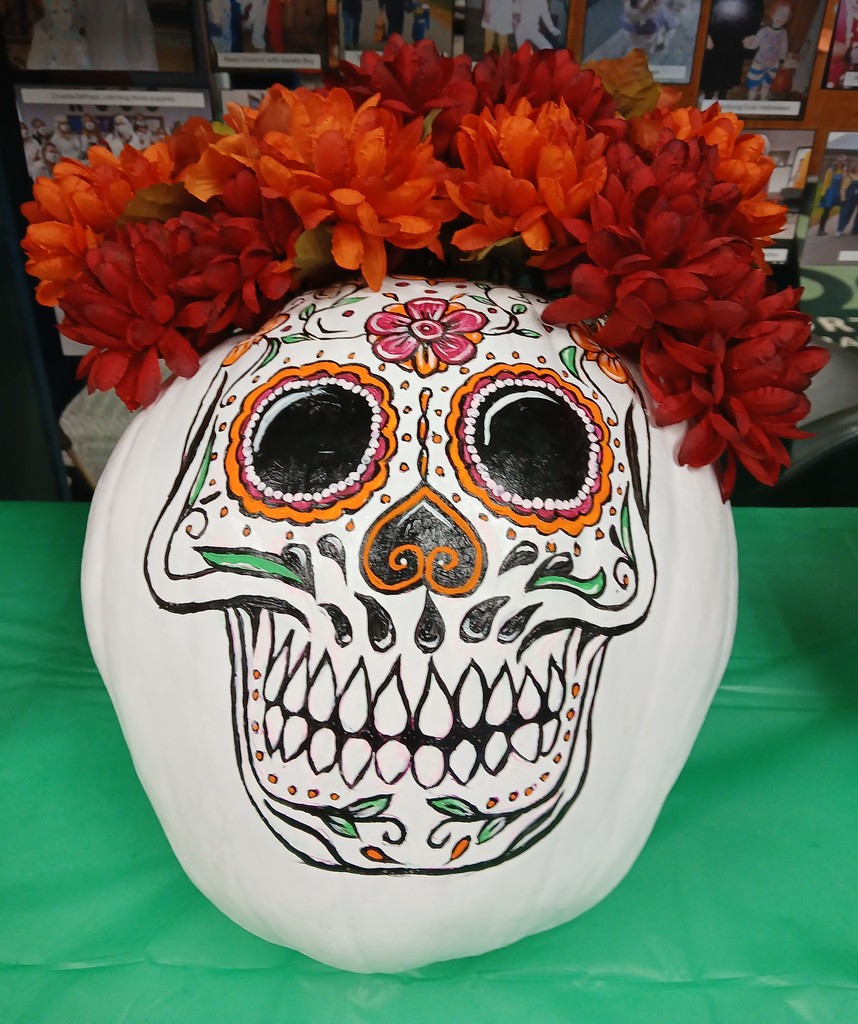 Decorated pumpkin with skull and flowers