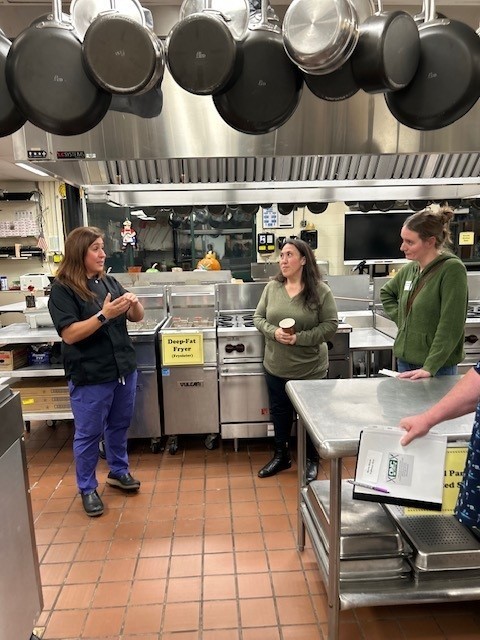NCOC Culinary instructor speaking to people in the kitchen