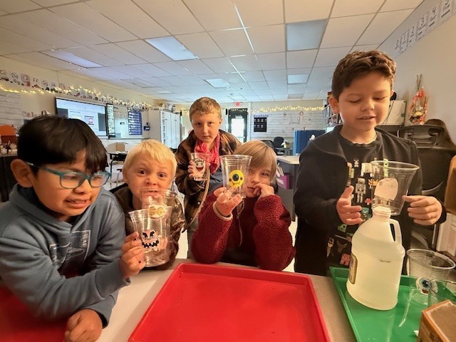 Five students with cups for a "learning through play" session