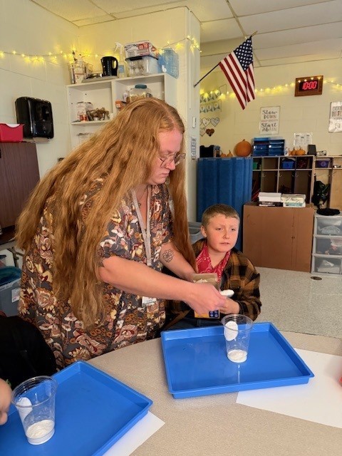 Student and teacher with a tray and cup