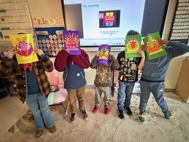 5 students holding pictures of monsters in front of their faces