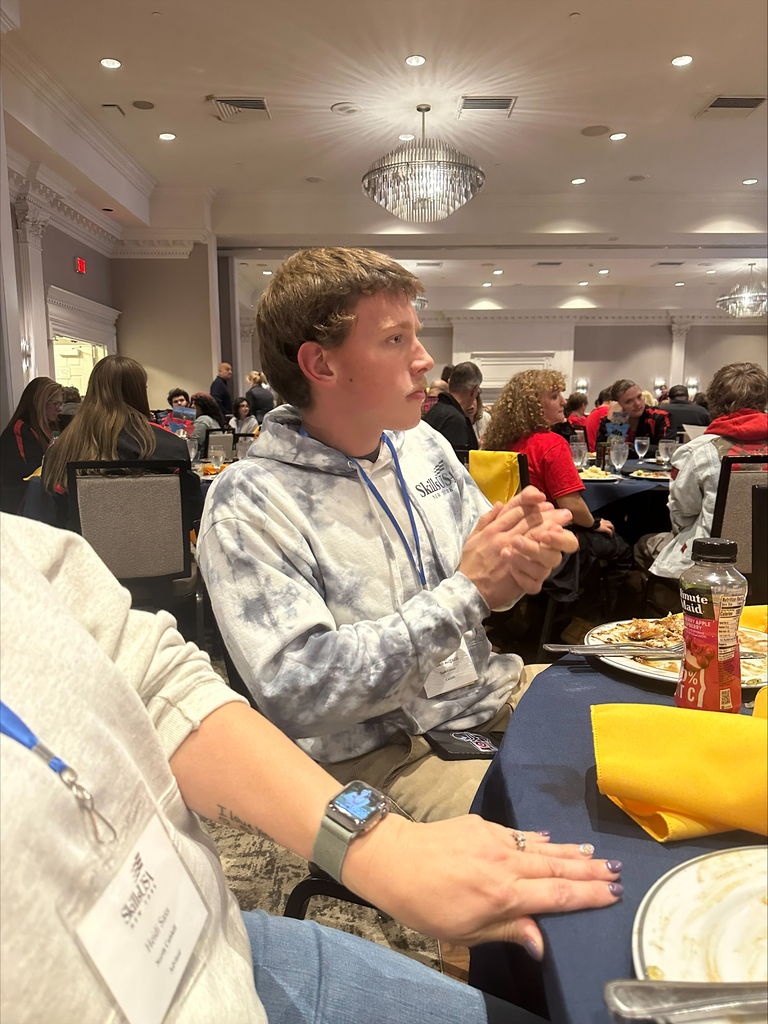 Student sitting at a table clapping