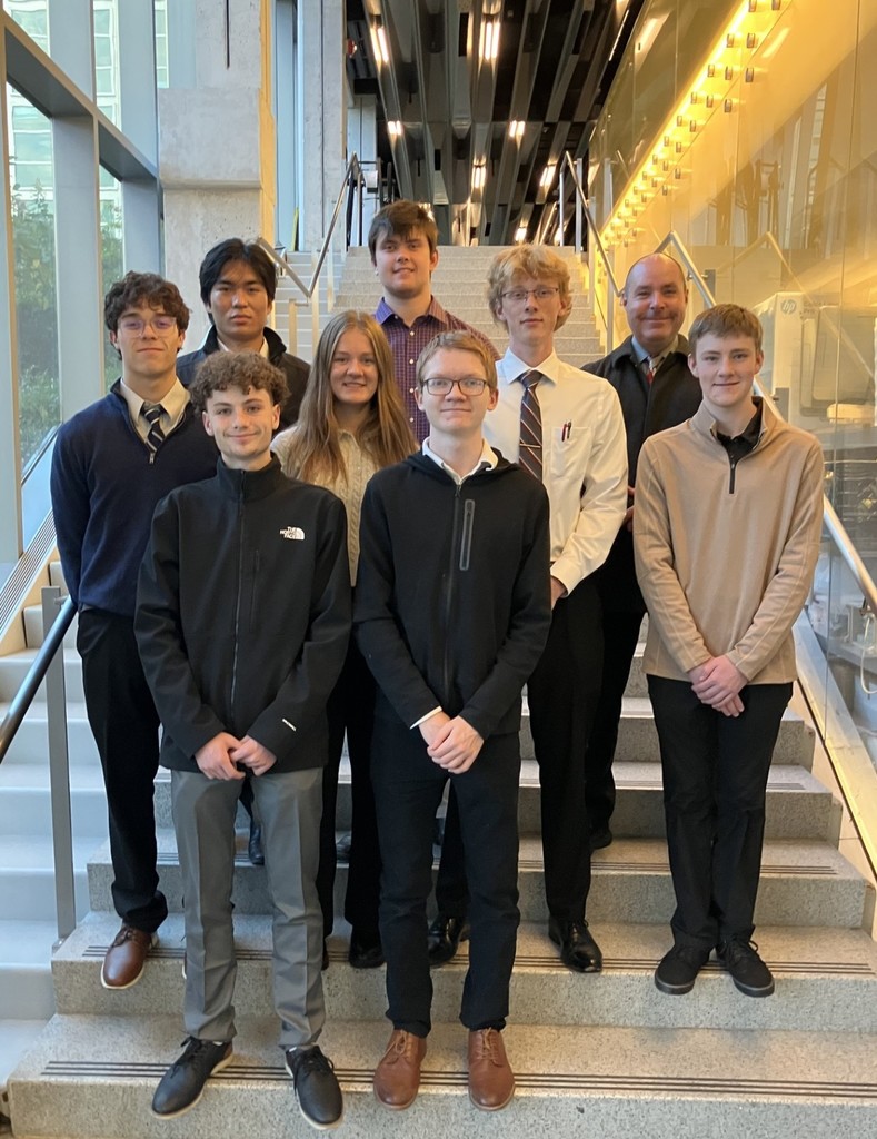Students and instructor posing on stairs at Cornell