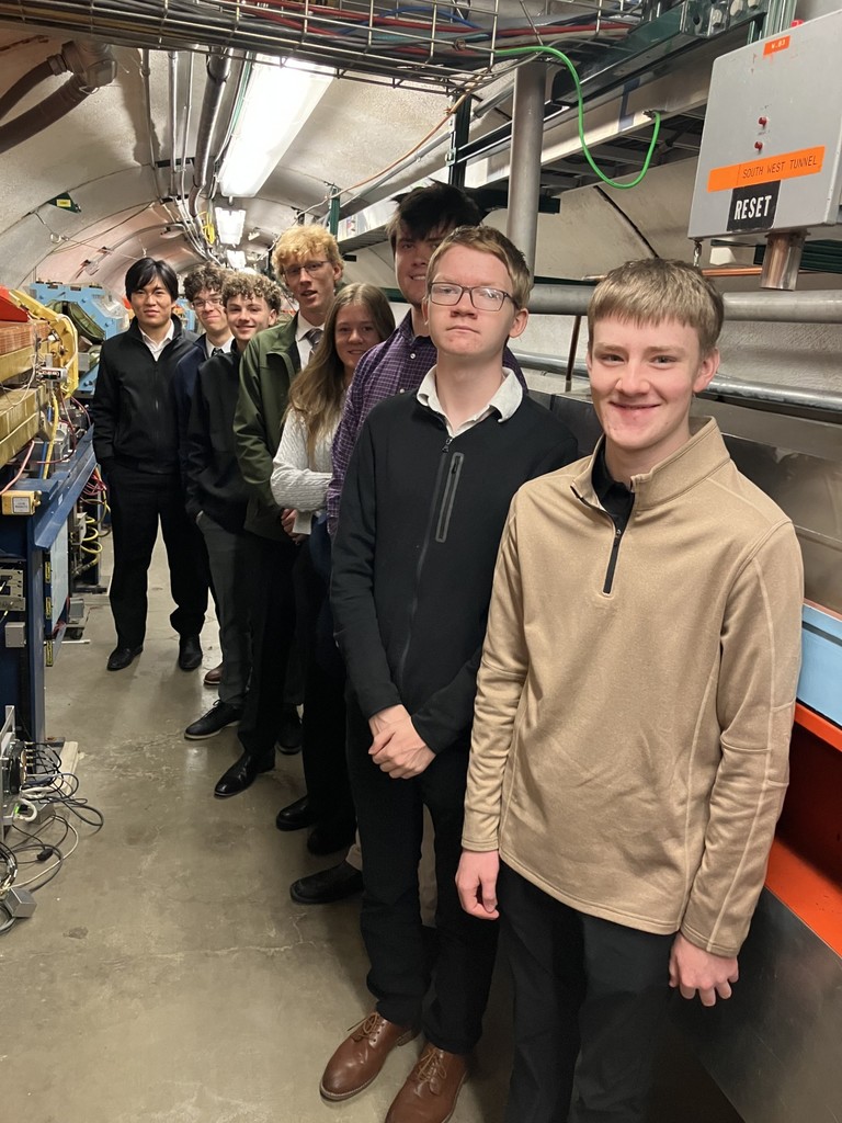 Students posing near engineering equipment