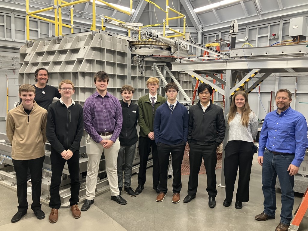 Students and staff members standing near the Cornell Magnet