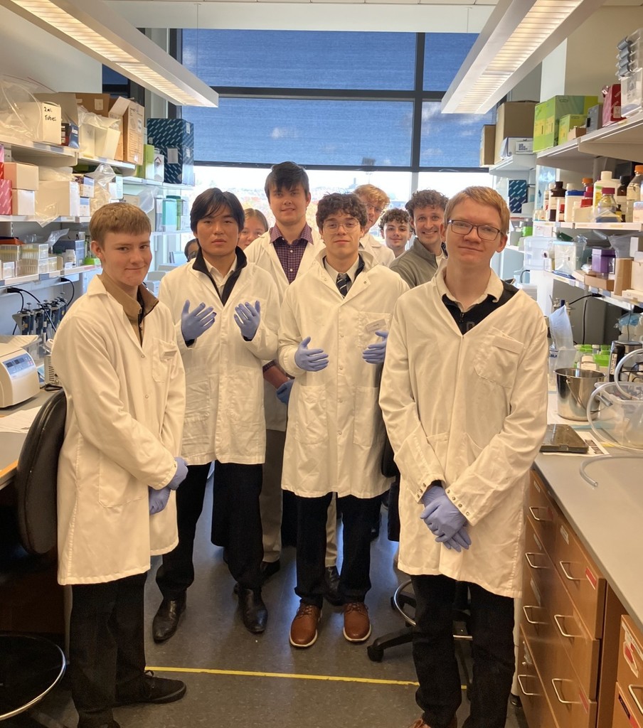 Students in white coats and gloves in the Cornell Bio Lab 