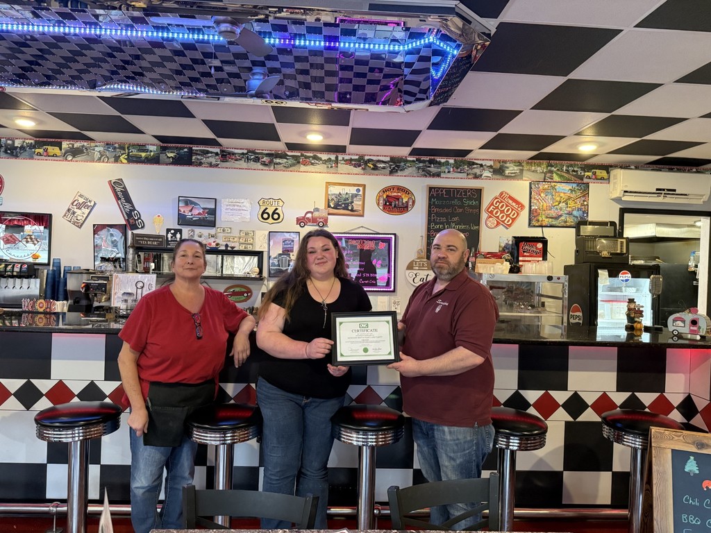 Two Sundaes' workers with NCOC student holding a certificate for the restaurant
