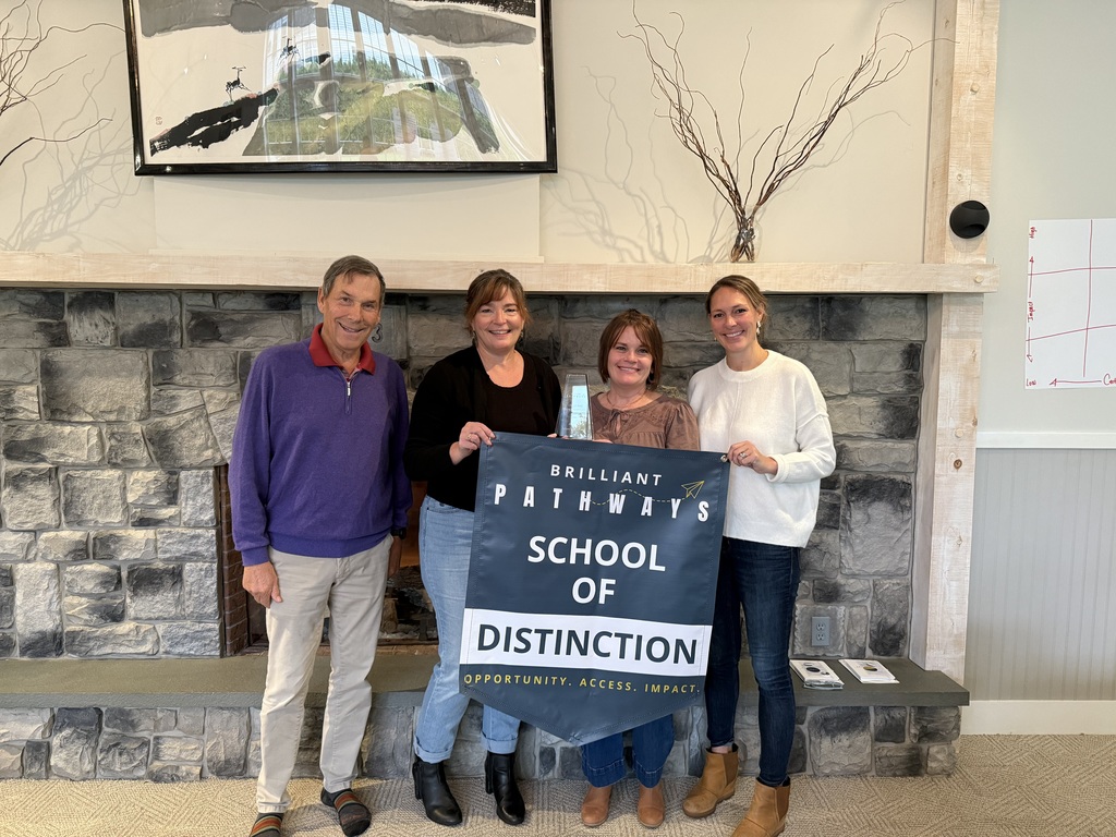 Four people holding a sign that says Brilliant Pathways School of Distinction