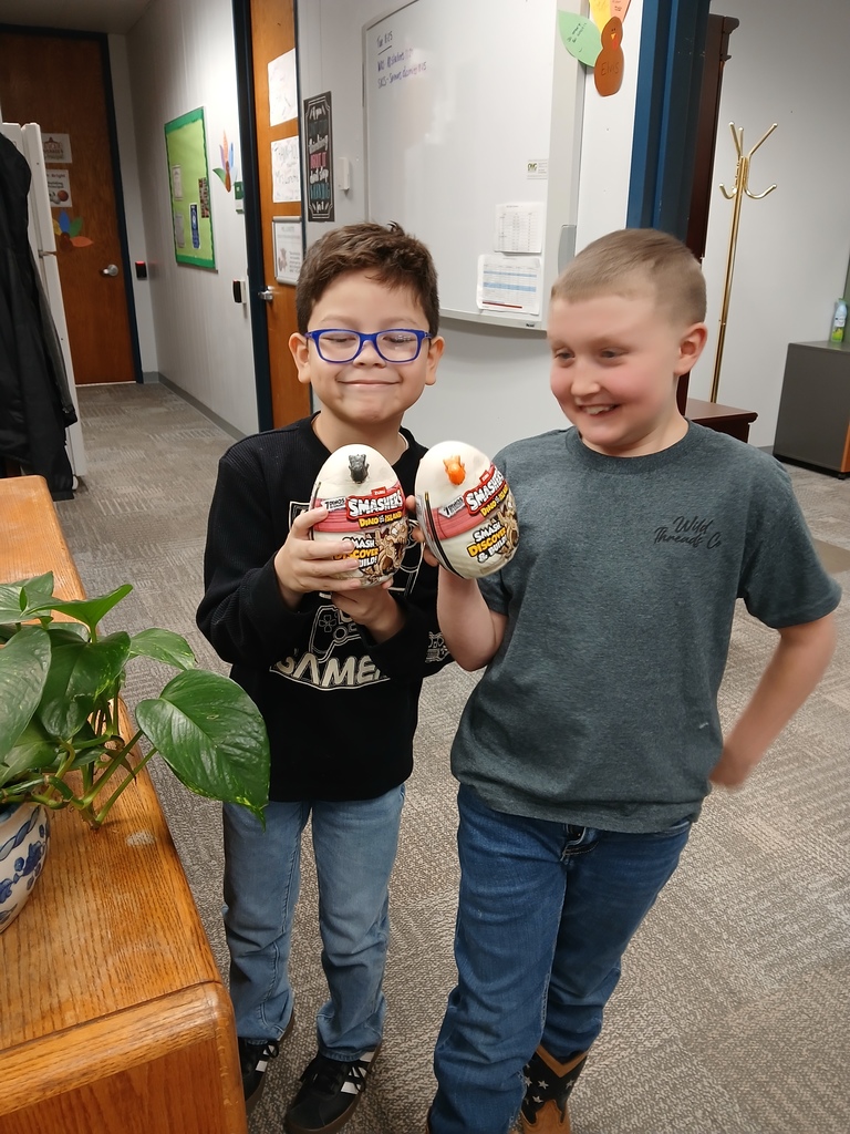 Two elementary student with dinosaur eggs