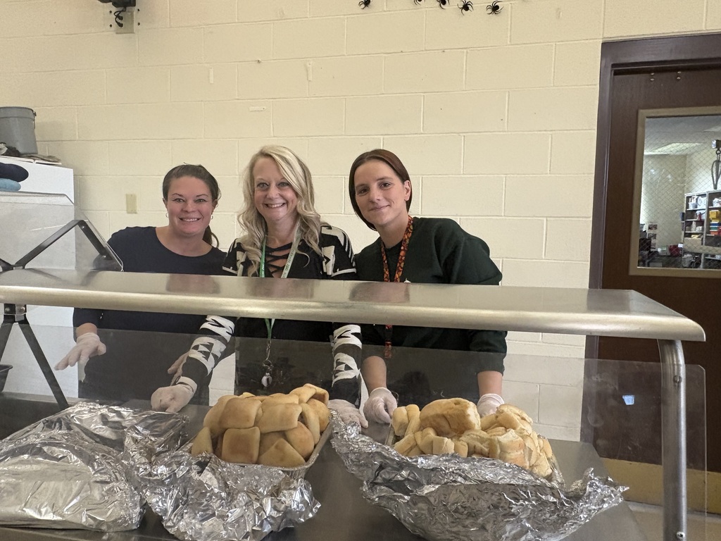 Three staff members serving thanksgiving lunch to students