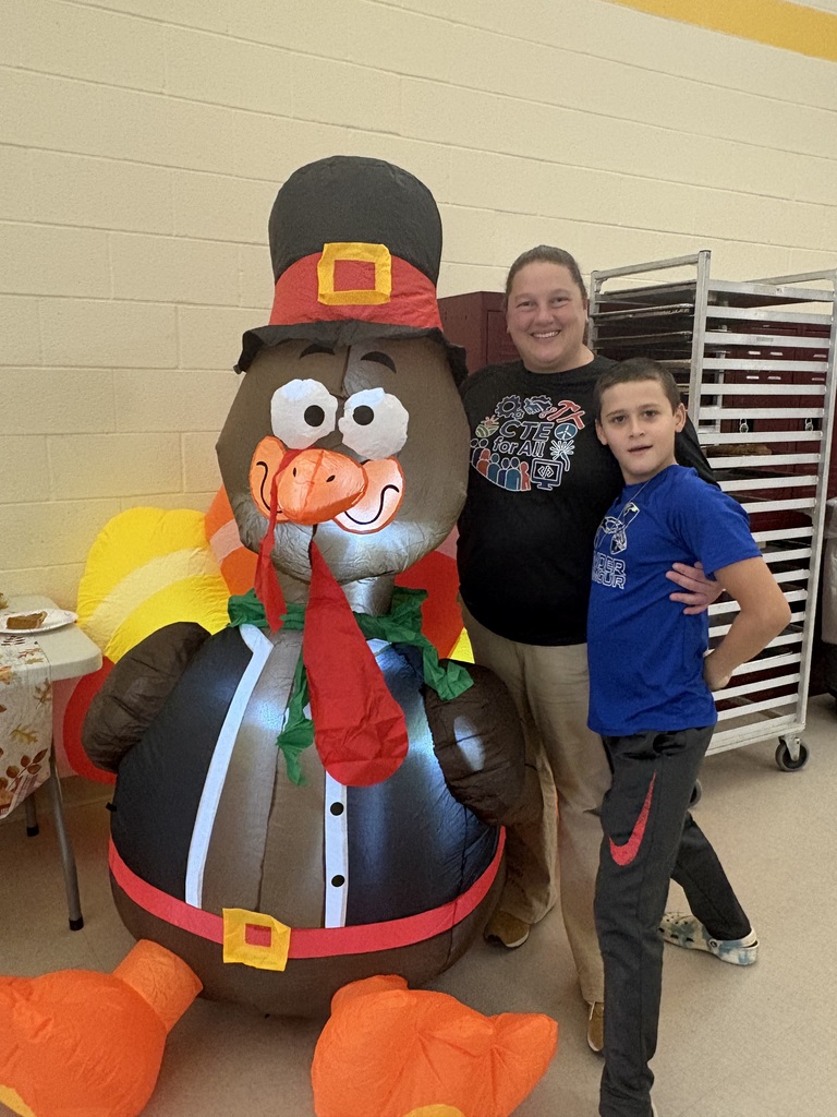 OAOC Principal and elementary student standing next to inflatable turkey