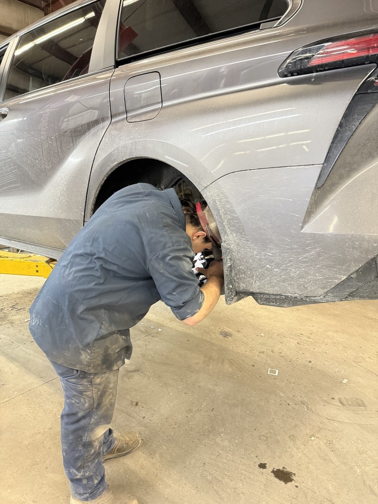 Student working on car brakes with the car on the lift